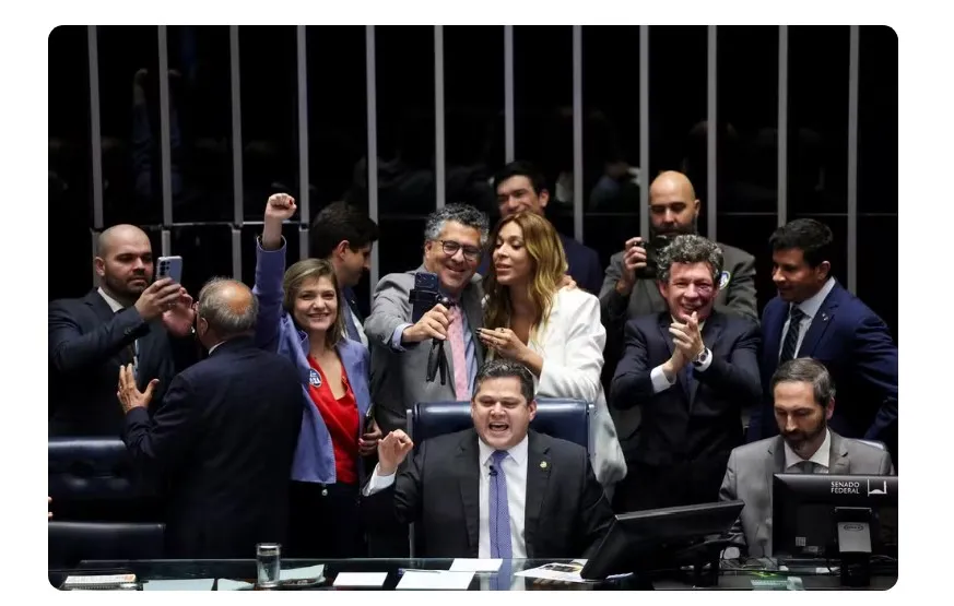 Colegas parlamentares comemoram enquanto o presidente do Senado Federal, Davi Alcolumbre, anuncia o resultado da votação a favor de uma emenda constitucional que reduz a jornada de trabalho no Brasil de seis para cinco dias, em Brasília, Brasil, 14 de out